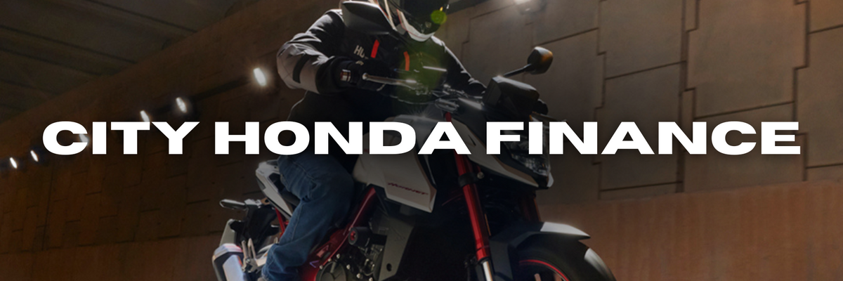 A person wearing protective gear rides a motorcycle inside a tunnel. The words "City Honda Finance" are prominently displayed across the image.