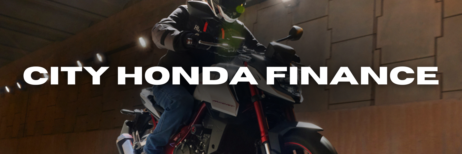 A person wearing protective gear rides a motorcycle inside a tunnel. The words "City Honda Finance" are prominently displayed across the image.