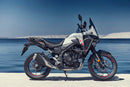 The Honda NX500, a sleek and modern motorcycle by Honda, showcases a silver and black color scheme with programmed fuel injection. It features a prominent windshield, angular design elements, and alloy wheels. The side profile accentuates its sporty and aerodynamic build.