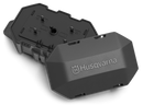 A black Husqvarna Automower® Area Switch, featuring the brand name on its cover, is partially open to display interior connectors and boundary wire components against a black background.