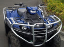A Yamaha YFM 450 FBP Kodiak (17-21) by Ventura, in blue with a company logo and robust metal bars, is parked on pavement. It has large rugged tires and is set against lush greenery with yellow flowers.