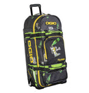 The OGIO RIG 9800 - The Booty Limited Edition is a large black bag with yellow and green accents, bottle and character graphics, gear protection, telescoping handle, multiple compartments, and "The Booty" & "Rig 9800" on the front.