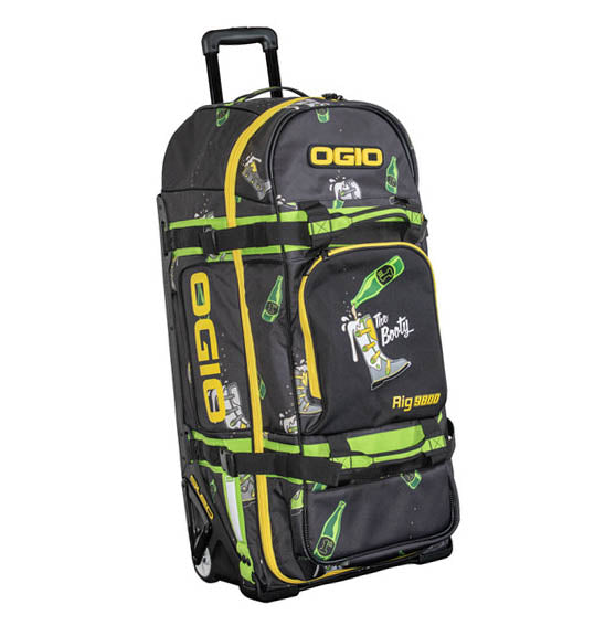 The OGIO RIG 9800 - The Booty Limited Edition is a large black bag with yellow and green accents, bottle and character graphics, gear protection, telescoping handle, multiple compartments, and "The Booty" & "Rig 9800" on the front.
