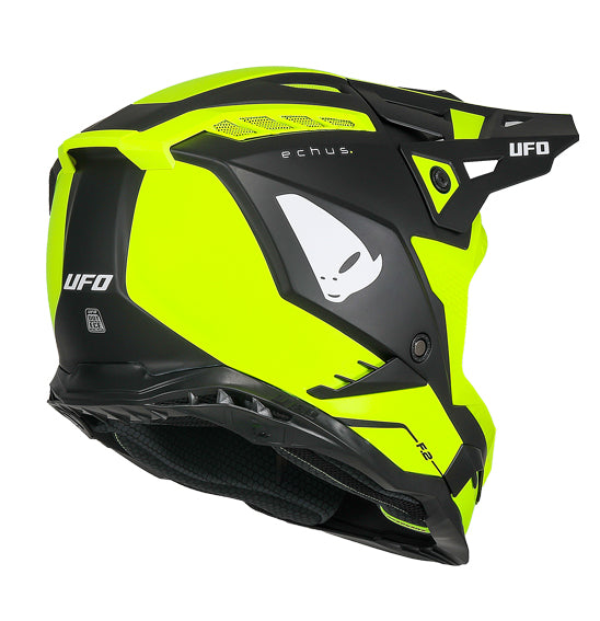 The UFO Echus Helmet in neon yellow and black features angular geometric designs, an alien logo near the back, and "UFO" branding. ECE 22.06 certified, it ensures top-notch safety for off-road adventures with its visor-equipped design.