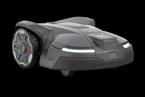 The image shows a Husqvarna Automower® 450X NERA robotic lawn mower. It features a sleek, gray and black design with LED headlights, large rubber wheels, and a red power button. The Husqvarna logo and model name are visible on the body. Integrated with object avoidance and compatible with the Automower Connect app.