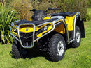 A Ventura Can-Am ATV Outlander G2 500 (12-13) in yellow with black and silver accents, sturdy bull-bars, a robust frame, and rugged tires is parked on grass amid greenery, designed for off-road adventures.