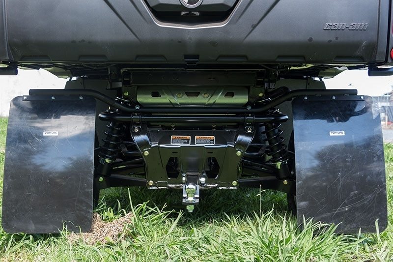 A Ventura Can-Am ATV Defender HD10 (16-17), painted yellow and black, is parked on grassy terrain. This off-road utility vehicle features rugged tires, a sturdy bull-bar, a protective front grille, mud flaps, and two side mirrors against a backdrop of greenery and a partly cloudy sky.