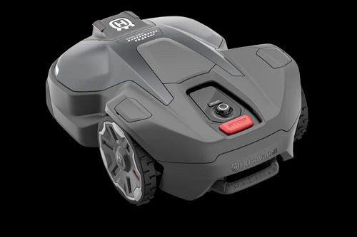 The image shows a Husqvarna Automower® 450X NERA robotic lawn mower. It features a sleek, gray and black design with LED headlights, large rubber wheels, and a red power button. The Husqvarna logo and model name are visible on the body. Integrated with object avoidance and compatible with the Automower Connect app.