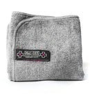 The Muc-Off Microfibre Polishing Cloth by MUC OFF features packaging with a striking black, white, and pink design adorned with a bold "X" and droplet icon. Ideal for helmets, visors, and goggles, it is crafted using advanced split-fibre technology to ensure it is both reusable and efficient. Plus, this cloth is machine washable.