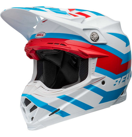 The Bell MOTO-9S FLEX Banshee Gloss White/Red is a safety-focused, full-face motocross helmet adorned with a striking blue, red, and white geometric design. It features a visor, multiple ventilation openings, and the brand name "BELL" in blue on the side. The interior padding is visible around the face opening, making it perfect for off-road racing.