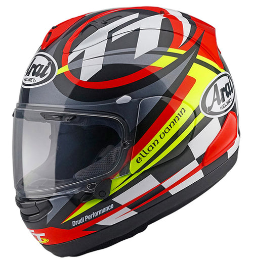 The Arai RX-7V EVO - IOM TT 2023 Limited Edition motorcycle helmet features vibrant graphics in red, black, white, and neon yellow. This colorful design includes the Arai logo, an "Isle of Man" label, and a stylized flag design. The helmet comes with a clear visor, meets ECE R22-06 standards, and boasts an aerodynamic shape perfect for the Arai Isle of Man TT.