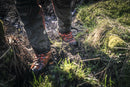 A pair of orange and black Husqvarna Protective leather boots with saw protection - Technical 24 with rugged soles. The boots feature red and black laces, a reinforced toe area, and detailed stitching. One boot stands upright while the other is tilted to show its tread pattern, making them perfect motorcycle accessories for adventurous rides.