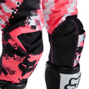 The FOX 180 DIGI IMAGE PANTS feature a pink, black, and white geometric camo design, black knee panels, and a FOX logo on the thigh—built for dirt bike riders seeking comfort and mobility in the Rider Attack Position. Displayed on a white background.