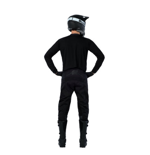 Person wearing a black motorcycle helmet, an O'Neal ELEMENT Classic Jersey - Black by ONEAL made from breathable moisture-wicking material, pants designed with durable wear-resistant panels, and boots. They stand with their hands on their hips, facing away from the camera against a white background.