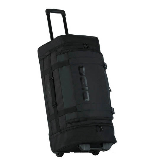 The OGIO CRAWLER Gear Bag - Black is a large wheeled gear bag featuring off-road wheels, a retractable handle, side straps, and a spacious main compartment. It is shown upright and slightly angled to the right.