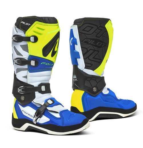 A pair of Forma Pilot - MX motocross boots in black and white, featuring multiple buckles and protective padding. These boots, crafted with a synthetic material upper, showcase the "FORMA" brand prominently on the shin guards and side areas. They boast a sturdy, reinforced design with textured soles for enhanced grip and durability.