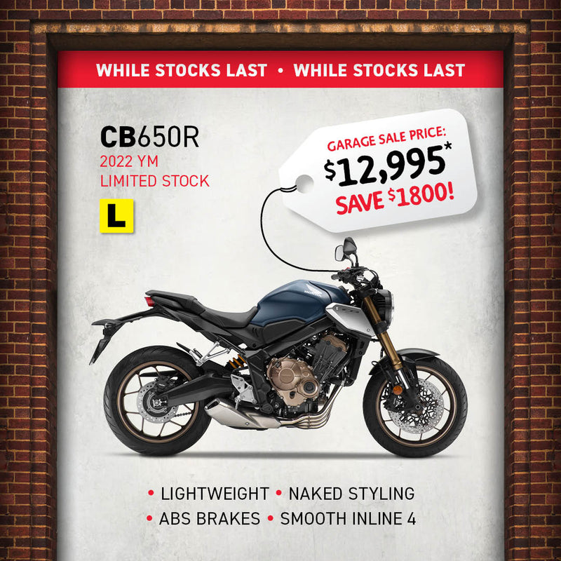 Image of a 2022 Honda CB650R motorcycle with a garage sale tag priced at $12,995, saving you $1,800. Features lightweight Neo Sports Café styling, ABS brakes, and a smooth inline-four engine. "While stocks last" text on a brick wall background.