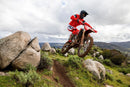 The 2025 Honda CRF450RX off-road motorcycle, featuring a black seat and knobby tires, is displayed in side profile. It highlights a lightweight frame, visible suspension components, and the Honda logo prominently on the side. The bike is equipped with Honda Selectable Torque Control for optimal performance across diverse terrains.