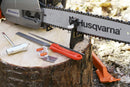 The Husqvarna File Handle - Suits Round and Flat File is expertly crafted with an ergonomic design and three central slits, making it ideal for comfortably carrying multiple tools at once. It features the word "Push" embossed at one end, set against a black background that highlights its patented file locking system.