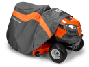 An orange Husqvarna riding lawn mower, partially covered by a gray and orange Husqvarna Garden Tractor Cover designed for side discharge tractors, with the front of the mower and part of the wheels visible. Made from water-resistant material, the cover ensures all-season protection. The Husqvarna logo is displayed on both the cover and the mower.