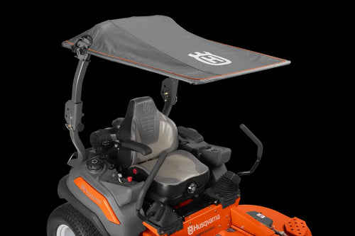 This Husqvarna Zero Turn lawn mower showcases an orange base, a black seat with steering controls, and a grey sun canopy supported by metal brackets above the seat. Both the body and the canopy prominently display the "Husqvarna" brand.