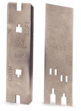 Two metallic saw blades are shown. The blade on the left is labeled “EM. SOFT” and “3/8” HARD,” while the blade on the right features the text “EM.” and “101.” Both blades have distinct cutouts, showing signs of wear, much like well-used Husqvarna Depth Gauges by Husqvarna.