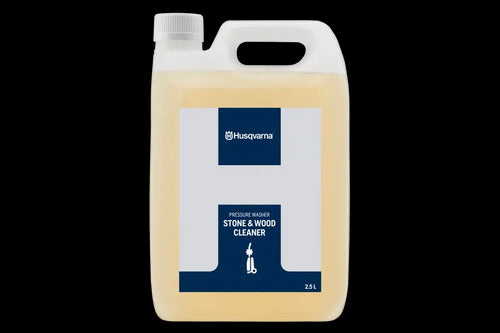 The "Husqvarna Stone and Wood Cleaner" is a white and blue rectangular plastic container with a handle on top, labeled as "Pressure Washer Stone & Wood Cleaner" by Husqvarna. It has a volume of 2.5 liters and contains a light yellow liquid that is perfect for cleaning bricks, wood, and pavements.