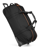 The Husqvarna Xplorer Trolley Bag 90L is a black rolling duffel bag with orange accents and the brand name "Husqvarna" printed on the side. This versatile trolley bag features rubber wheels, a retractable handle for easy transport, as well as padded handles and shoulder straps for comfortable carrying.