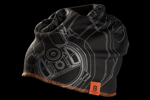 The Husqvarna Xplorer Beanie pioneer saw is a black beanie with an intricate grey mechanical drawing design, complemented by an orange hem and a tag that features the Husqvarna logo and illegible text. Made from Coolmax air material, this soft and stretchy fabric makes it perfect for cold weather.