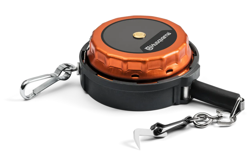 The Husqvarna Measuring Tape with release hook is a portable retractable dog leash in orange and black, featuring a carabiner clip on one end and a lock mechanism on the other. Resembling a robust measuring tape, it includes a sturdy handle and offers a 15m chain extension with a release hook for attaching to your dog's collar.