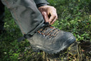 An image of Husqvarna Technical Extreme Waist trousers, high-visibility orange and black protective work pants with adjustable suspenders. These pants, made by Husqvarna, feature Cordura reinforcement at the knees and multiple pockets. The suspenders are adjustable and include reflective strips for enhanced visibility, making them ideal for forest work.
