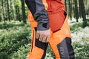 An image of Husqvarna Technical Extreme Waist trousers, high-visibility orange and black protective work pants with adjustable suspenders. These pants, made by Husqvarna, feature Cordura reinforcement at the knees and multiple pockets. The suspenders are adjustable and include reflective strips for enhanced visibility, making them ideal for forest work.
