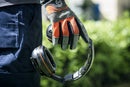 The Husqvarna Premium Earmuff with Headband features black over-ear cups adorned with silver accents and orange lining. Designed as hearing protectors, it has an adjustable headband with a padded cushion on top for optimal ergonomics during prolonged use. The Husqvarna logo is prominently displayed on the outer side of one ear cup.