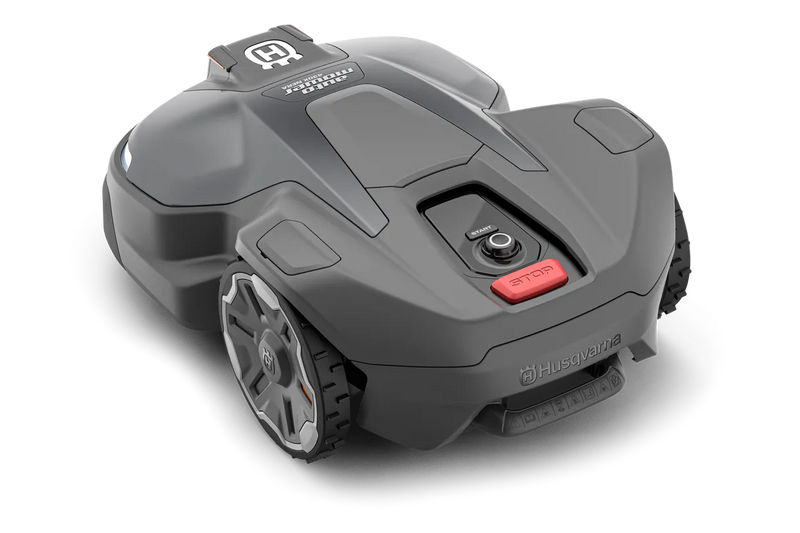The Husqvarna Automower 430X NERA is a sleek, grey robotic lawn mower featuring two large wheels at the rear and two smaller wheels at the front. It boasts a red stop button on top, LED headlights, and proudly displays the Husqvarna logo on the front. With its modern design, this mower is equipped with object avoidance technology and can be conveniently controlled via the Automower Connect app.