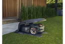 A gray Husqvarna branded attachment, likely a Husqvarna Aspire Automower® House - 320 NERA, 430X NERA, 450X NERA designed for a robotic lawn mower. Perfect for maintaining lawns and gardens, the attachment features a streamlined design with mounting points for secure installation.