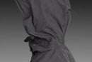 The Husqvarna Xplorer Shell Jacket, available in grape purple and aubergine purple for women, is crafted from 4-way stretch material. It features a front zipper, two zippered pockets, and a logo on the left sleeve. The chest showcases the text "BUSHMAN" vertically. With its wind and water repellent qualities, it also includes orange-accented zippers and a removable hood for versatility.