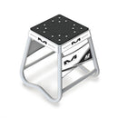 A white mini motorbike stand from Crown Kiwi Enterprises Limited, labeled as the "Mini A2 Stand White," features an aircraft-quality anti-rock design, a sturdy square platform, and angled legs for support.