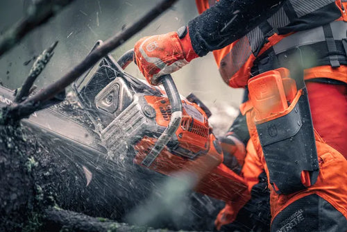 A Husqvarna 592 XP-32® Chainsaw with an orange body and silver cutting bar, featuring the Husqvarna logo and branding. Perfect for forestry tasks, the chainsaw has a robust design with a black handle and control elements visible on the top and side.