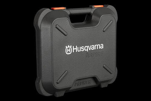 The Husqvarna Aspire™ Pruner Case is a black, hard plastic carrying case adorned with the Husqvarna logo and "ASPIRE" printed in white on the front. Reminiscent of rugged motorbike gear, it includes an ergonomic handle and an orange latch on top, with "PRUNER" embossed at the bottom.