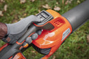 The Husqvarna 230iB Leaf Blower skin, featuring a brushless motor for enhanced efficiency, showcases a sleek orange design with black and gray accents. The "Husqvarna" name is proudly displayed on the tube, and its ergonomic handle ensures comfortable operation.