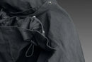 The Husqvarna Xplorer Shell Jacket Charcoal Black - Women by Husqvarna is a dark gray, hooded outdoor jacket. This windproof jacket features a full front zipper, zippered pockets, and subtle branding on the chest. It has long sleeves, adjustable ventilation, and a slightly fitted design, making it suitable for various weather conditions.