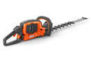 A Husqvarna 522iHDR60 Battery Hedge Trimmer - Skin only with a long blade featuring multiple cutting teeth, perfect for maintaining lawns. The device has a handle with a protective guard, a power button, and ergonomic design for efficient trimming. The Husqvarna brand label is visible on the side of the trimmer, ideal for outdoor use.