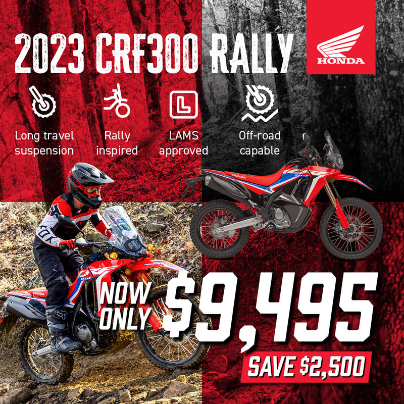 The Honda CRF300 Rally is a red and black adventure motorcycle with a windscreen, off-road tires, and blue & white accents. Designed for rugged terrain, it is highlighted on a plain white background, showcasing its sleek design and impressive off-road performance.