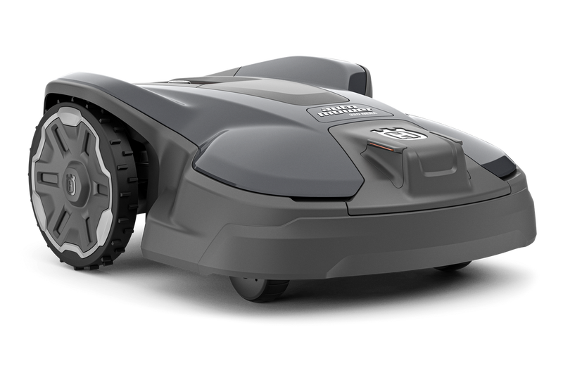 Image of the Husqvarna Automower 320 NERA. The robotic lawn mower features a sleek and modern design with a predominantly dark gray body, large rear wheels for high terrain performance, and a compact build. The Husqvarna logo is prominently displayed on top.