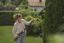 The Husqvarna Aspire™ Shrub Shear 18V (Skin) is a sleek, modern black and orange battery-operated hedge trimmer with an 18V POWER FOR ALL ALLIANCE system. It includes a detachable blade and interchangeable Shrub Shear attachment, displayed on a plain white background.