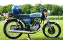 Ventura EVO-12 Bike-Pack Kit for Suzuki GT 125 (74-77): includes a black EVO-12 pack, sturdy Evo-Rack mounted to the motorcycle, and labeled L-Bracket set with screws, all shown on a clean white background.