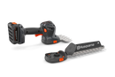 The Husqvarna Aspire™ Shrub Shear 18V (Skin) is a sleek, modern black and orange battery-operated hedge trimmer with an 18V POWER FOR ALL ALLIANCE system. It includes a detachable blade and interchangeable Shrub Shear attachment, displayed on a plain white background.