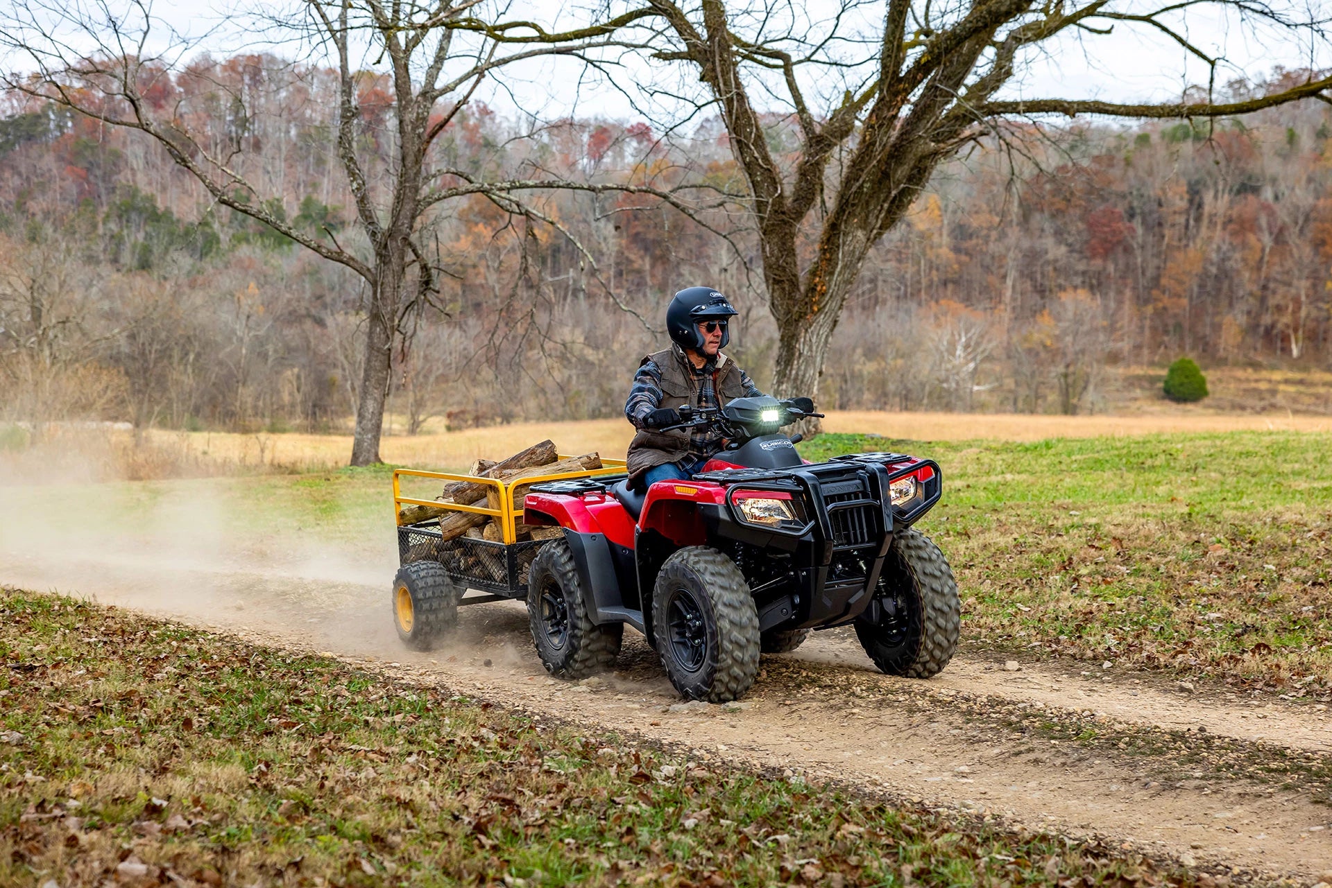 The Honda TRX700FA5 is a red and black all-terrain vehicle (ATV) built for off-road adventures. Featuring rugged tires and a sturdy build, it includes a four-wheel-drive system as well as front and rear cargo racks, blending sleek design with adventure-ready capability.