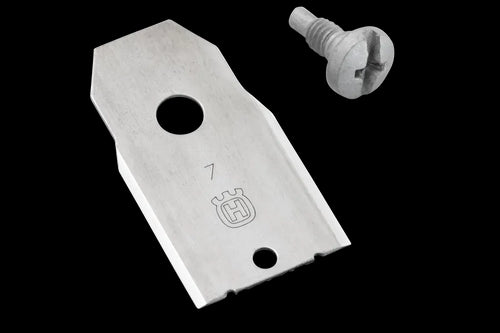 A Husqvarna Automower® Enhance HSS Blade, made from high-speed steel (HSS) and featuring a logo resembling a crowned emblem, sits next to a silver screw with a slotted head. The rectangular blade has angled corners, a large circular hole, and a smaller hole near its edge—perfect for the Husqvarna Automower.