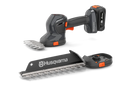 The Husqvarna Aspire™ Shrub Shear 18V (Skin) is a sleek, modern black and orange battery-operated hedge trimmer with an 18V POWER FOR ALL ALLIANCE system. It includes a detachable blade and interchangeable Shrub Shear attachment, displayed on a plain white background.